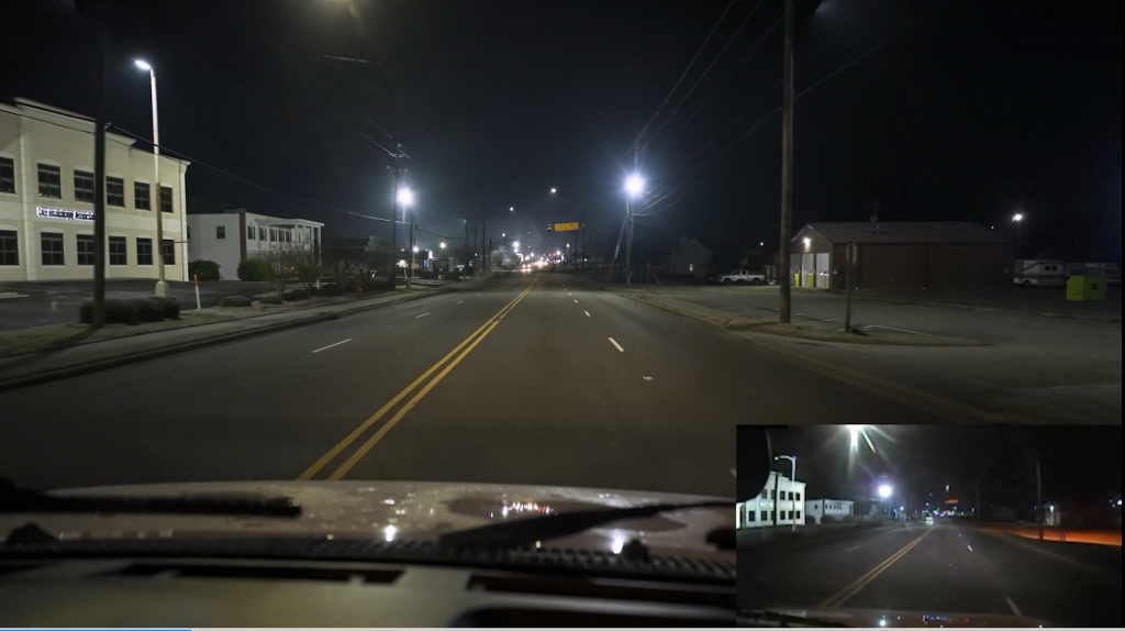 Looking down a dark city road with dashcam in the corner